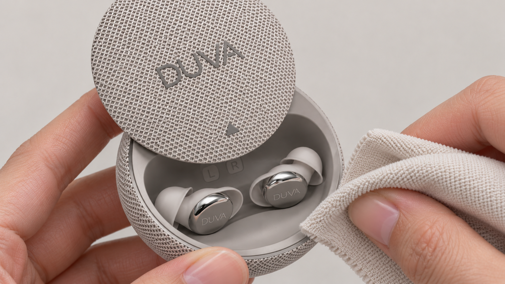An open DUVA charging case with earbuds inside, held next to a soft cleaning cloth